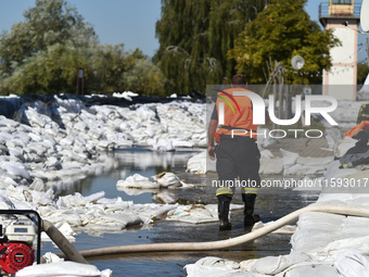 A firefighter walks on the flood barrier on the bank of the Danube in Vac, Hungary, about 42 km from Budapest, as the peak water levels of t...