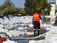 A firefighter walks on the flood barrier on the bank of the Danube in Vac, Hungary, about 42 km from Budapest, as the peak water levels of t...