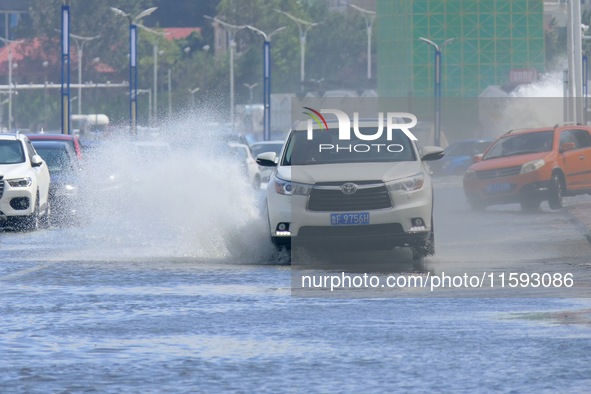 Cars pass a section covered with sea water on Binhai North Road in Yantai, China, on September 21, 2024. 