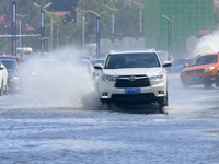 Cars pass a section covered with sea water on Binhai North Road in Yantai, China, on September 21, 2024. (