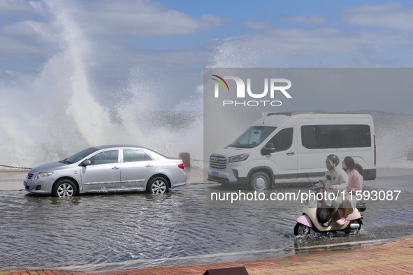 Cars pass a section covered with sea water on Binhai North Road in Yantai, China, on September 21, 2024. 