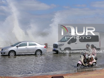 Cars pass a section covered with sea water on Binhai North Road in Yantai, China, on September 21, 2024. (