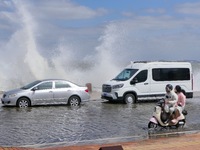 Cars pass a section covered with sea water on Binhai North Road in Yantai, China, on September 21, 2024. (