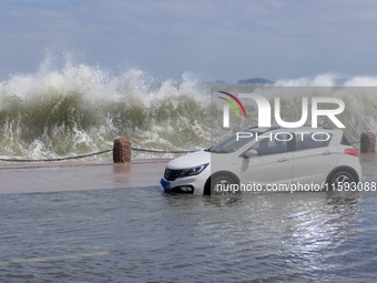 Big waves hit vehicles on Binhai North Road in Yantai, Shandong province, China, on September 21, 2024. (