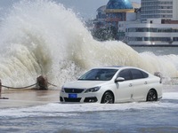 Big waves hit vehicles on Binhai North Road in Yantai, Shandong province, China, on September 21, 2024. (