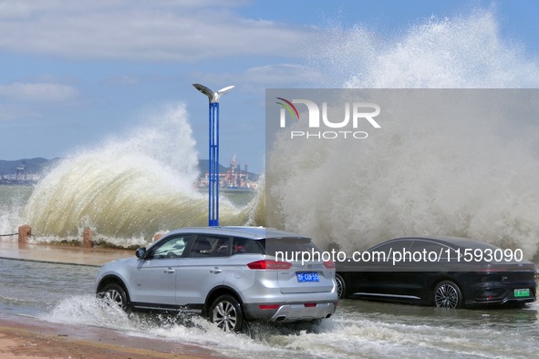 Cars pass a section covered with sea water on Binhai North Road in Yantai, China, on September 21, 2024. 