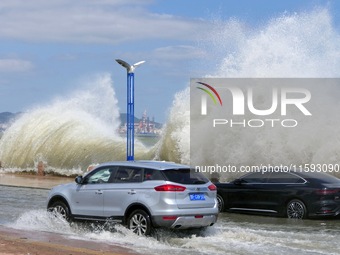 Cars pass a section covered with sea water on Binhai North Road in Yantai, China, on September 21, 2024. (