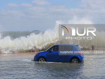 Big waves hit vehicles on Binhai North Road in Yantai, Shandong province, China, on September 21, 2024. (