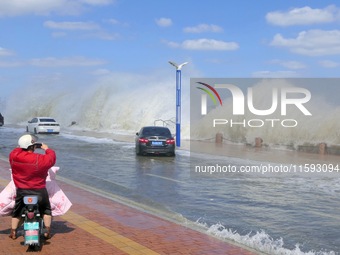 People take photos of waves on Binhai North Road in Yantai, China, on September 21, 2024. (