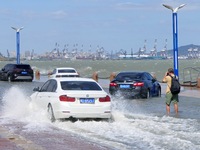 Cars pass a section covered with sea water on Binhai North Road in Yantai, China, on September 21, 2024. (