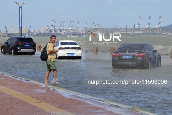 Cars pass a section covered with sea water on Binhai North Road in Yantai, China, on September 21, 2024. 