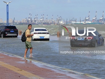 Cars pass a section covered with sea water on Binhai North Road in Yantai, China, on September 21, 2024. (