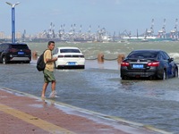 Cars pass a section covered with sea water on Binhai North Road in Yantai, China, on September 21, 2024. (