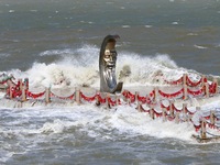 The base of the statue of the Old Man of the Moon is submerged by the tide at the Moon Bay scenic spot in Yantai, China, on September 21, 20...