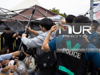 Police forcibly dismantle tents set up for a sit-in protest by around 50 members of the Progressive Union of Korean University Students in f...