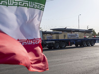 Iran's first-ever hypersonic missile, Fattah, is carried past an Iranian flag by a truck during a military parade commemorating the annivers...