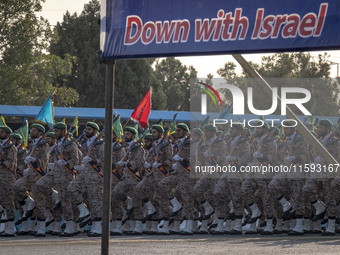 Islamic Revolutionary Guard Corps (IRGC) military personnel march under an anti-Israeli banner in a military parade commemorating the annive...