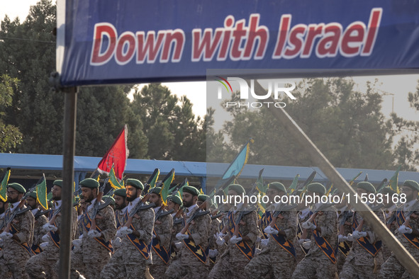 Islamic Revolutionary Guard Corps (IRGC) military personnel march under an anti-Israeli banner in a military parade commemorating the annive...