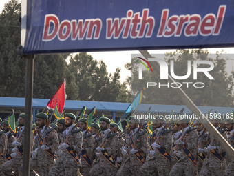 Islamic Revolutionary Guard Corps (IRGC) military personnel march under an anti-Israeli banner in a military parade commemorating the annive...