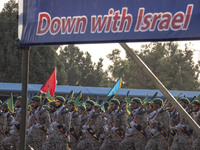 Islamic Revolutionary Guard Corps (IRGC) military personnel march under an anti-Israeli banner in a military parade commemorating the annive...