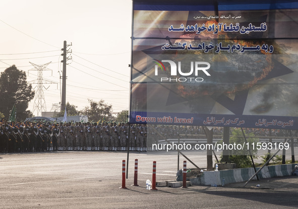 Islamic Revolutionary Guard Corps (IRGC) military personnel march next to an anti-Israeli banner in a military parade commemorating the anni...