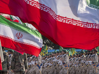 Islamic Revolutionary Guard Corps (IRGC) military personnel march under Iranian flags in a military parade commemorating the anniversary of...