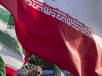 Islamic Revolutionary Guard Corps (IRGC) military personnel march under Iranian flags in a military parade commemorating the anniversary of...