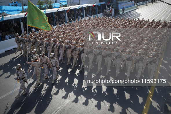 Armed Iranian border police personnel march in a military parade commemorating the anniversary of the Iran-Iraq War (1980-88) outside the Kh...