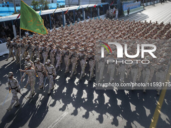 Armed Iranian border police personnel march in a military parade commemorating the anniversary of the Iran-Iraq War (1980-88) outside the Kh...