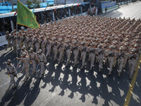 Armed Iranian border police personnel march in a military parade commemorating the anniversary of the Iran-Iraq War (1980-88) outside the Kh...