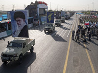 Portraits of Iran's Supreme Leader, Ayatollah Ali Khamenei, and a badge of the Islamic Revolutionary Guard Corps (IRGC), are carried by mili...