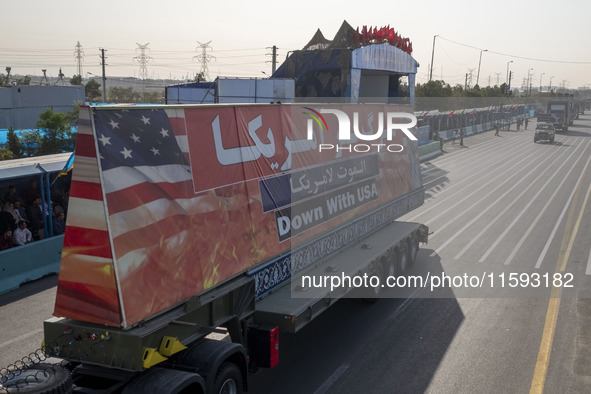 A truck carries a giant anti-U.S. banner during a military parade commemorating the anniversary of the Iran-Iraq War (1980-88) outside the K...