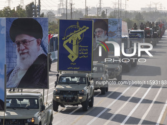 Portraits of Iran's Supreme Leader, Ayatollah Ali Khamenei, and a badge of the Islamic Revolutionary Guard Corps (IRGC), are carried by mili...