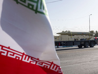 An Iran-made missile, Haj Qassem Soleimani, is carried past an Iranian flag by a truck during a military parade commemorating the anniversar...