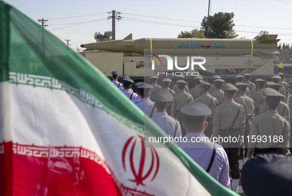 An Iran-made missile, Haj Qassem Soleimani, is carried past an Iranian flag by a truck during a military parade commemorating the anniversar...