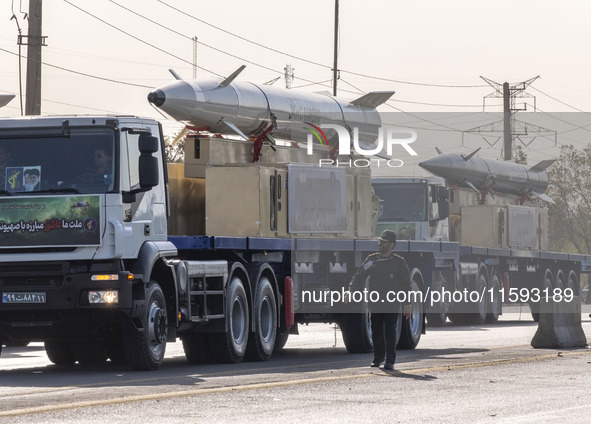 Iran's first-ever hypersonic missile, Fattah (R), and the Iranian Kheibar Shekan Ballistic missile, are carried by trucks during a military...