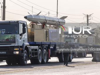 Iran's first-ever hypersonic missile, Fattah (R), and the Iranian Kheibar Shekan Ballistic missile, are carried by trucks during a military...