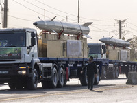 Iran's first-ever hypersonic missile, Fattah (R), and the Iranian Kheibar Shekan Ballistic missile, are carried by trucks during a military...