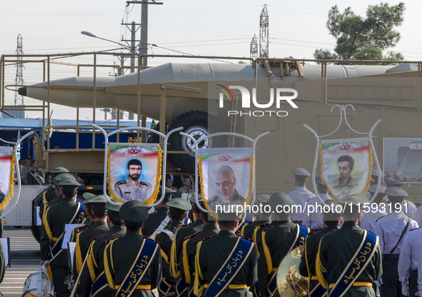 An Iranian ballistic missile is carried past a portrait of former commander of the Islamic Revolutionary Guard Corps' (IRGC) Quds Force, Gen...