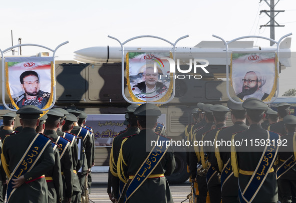 An Iranian missile is carried past a portrait of killed Hamas leader Esmail Haniyeh during a military parade commemorating the anniversary o...