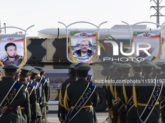 An Iranian missile is carried past a portrait of killed Hamas leader Esmail Haniyeh during a military parade commemorating the anniversary o...