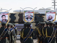 An Iranian missile is carried past a portrait of killed Hamas leader Esmail Haniyeh during a military parade commemorating the anniversary o...