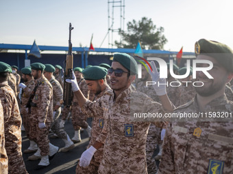 An armed Islamic Revolutionary Guard Corps (IRGC) military personnel flashes a Victory sign after marching in a military parade commemoratin...