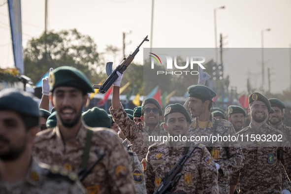 An armed Islamic Revolutionary Guard Corps (IRGC) military personnel flashes a Victory sign after marching in a military parade commemoratin...