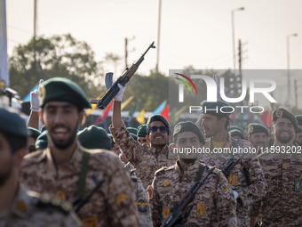 An armed Islamic Revolutionary Guard Corps (IRGC) military personnel flashes a Victory sign after marching in a military parade commemoratin...