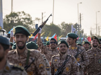 An armed Islamic Revolutionary Guard Corps (IRGC) military personnel flashes a Victory sign after marching in a military parade commemoratin...