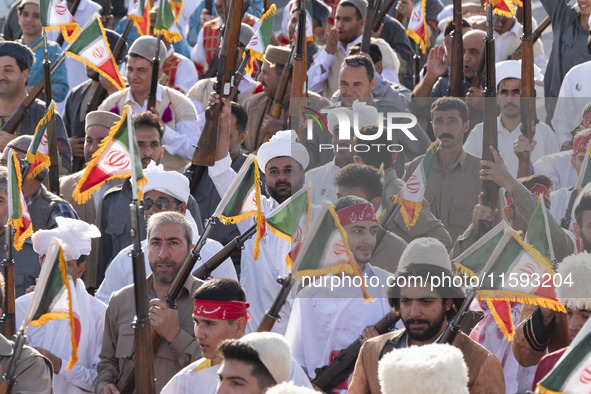 Armed members of the Basij Paramilitary Force, which is under the command of the Islamic Revolutionary Guard Corps, hold up their rifles aft...