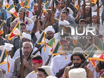 Armed members of the Basij Paramilitary Force, which is under the command of the Islamic Revolutionary Guard Corps, hold up their rifles aft...