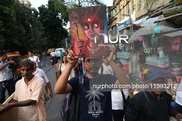 Indian artists protest with their paintings while they shout slogans during a protest rally against the rape and murder of a PGT woman docto...