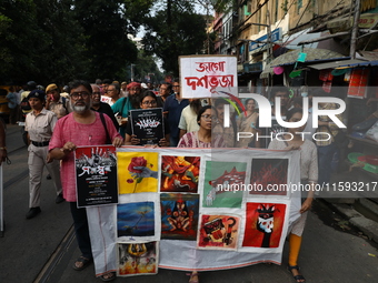 Indian artists protest with their paintings while they shout slogans during a protest rally against the rape and murder of a PGT woman docto...